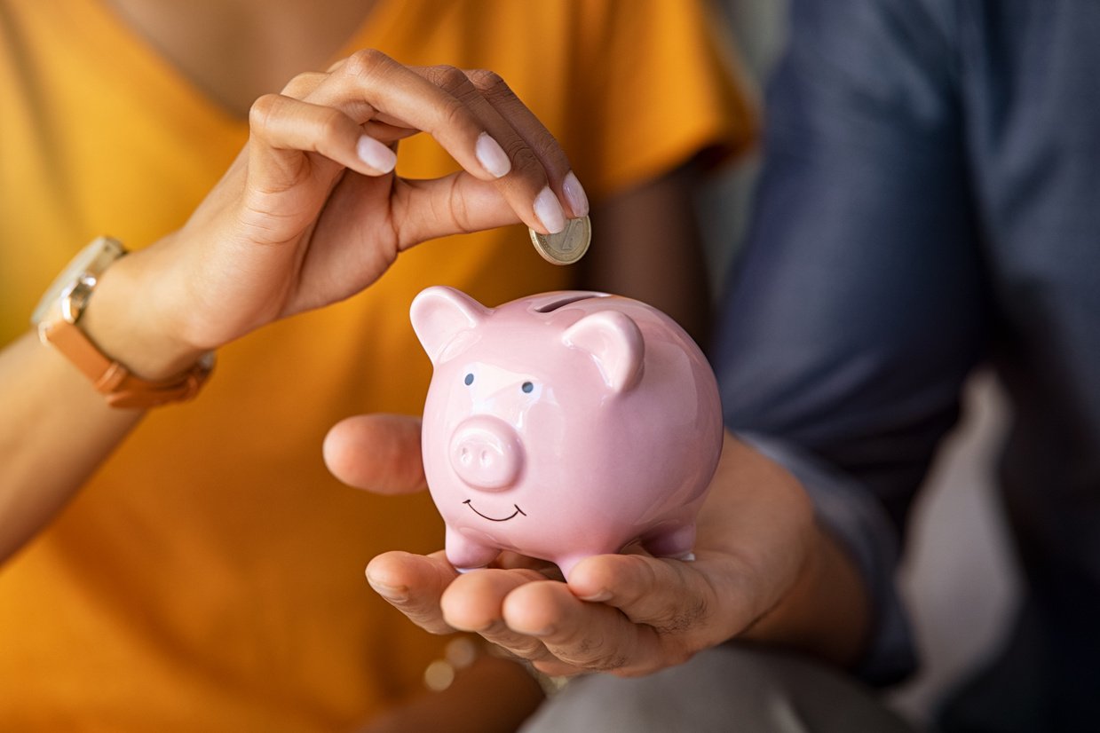 Couple saving money in piggybank